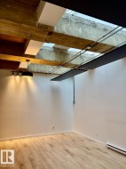 Exposed concrete beams and wood-finish flooring - 
