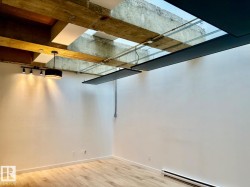 Exposed concrete ceiling beams with skylights and track lighting - 