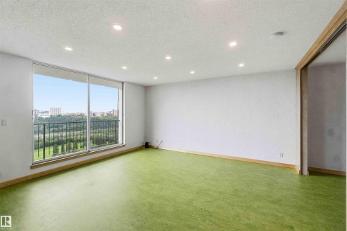 Spacious room featuring floor-to-ceiling windows, recessed lighting, wood-finish trim, and green flooring - 1008 11307 99 Avenue, Edmonton, AB 