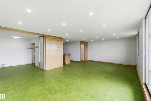 Spacious room featuring green flooring, recessed lighting, and a sliding glass door - 1008 11307 99 Avenue, Edmonton, AB 