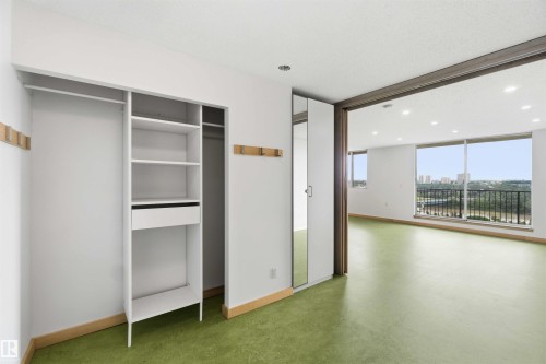Built-in closet system with shelving and hanging rods, complemented by a full-length mirrored door - 1008 11307 99 Avenue, Edmonton, AB 