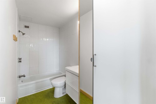 Bathroom featuring a white bathtub, white toilet, and white vanity with a rectangular sink - 1008 11307 99 Avenue, Edmonton, AB 