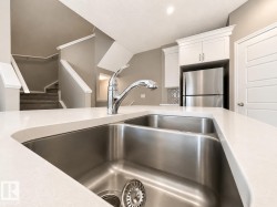 Kitchen island featuring a double basin stainless steel sink with a chrome faucet - 