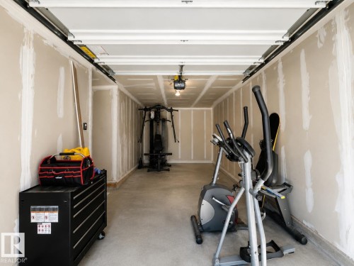 Spacious garage featuring concrete flooring and unfinished drywall - 20104 19 Avenue, Edmonton, AB 
