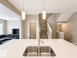 Kitchen island featuring a dual stainless steel sink and a contemporary chrome faucet - 