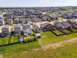 Aerial perspective highlighting a residential neighborhood with detached homes, fenced backyards, and mature landscaping - 
