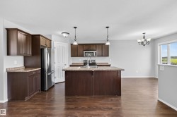 Kitchen featuring wood-finish flooring and dark wood cabinetry - 