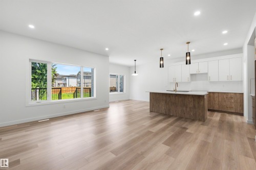Open-concept living space featuring wood-finish flooring, recessed lighting, and large windows - 30 Elsinore Place, Edmonton, AB 