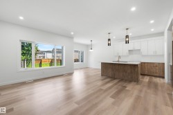 Open-concept living space featuring wood-finish flooring, recessed lighting, and large windows - 
