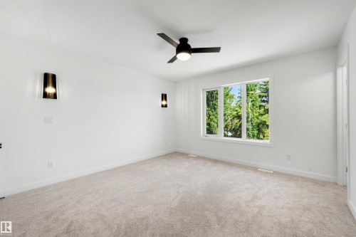 Carpeted room with a multi-pane window and a black ceiling fan - 30 Elsinore Place, Edmonton, AB 
