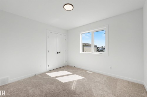 Room featuring neutral-toned carpeting and white walls with matching baseboards - 30 Elsinore Place, Edmonton, AB 