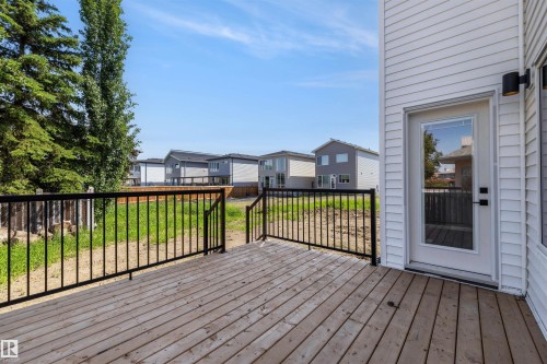 Expansive wooden deck featuring black metal railings and direct access to the interior via a glass-paneled door - 30 Elsinore Place, Edmonton, AB 