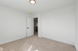 Neutral wall finishes with a modern door featuring matte black hardware, recessed lighting, and soft carpet flooring - 