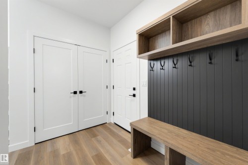 Entryway featuring wood-finish flooring, white walls, and a built-in mudroom bench - 30 Elsinore Place, Edmonton, AB 