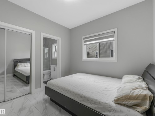 Room featuring light gray walls, large window with blinds, and white tiled flooring - 2412 14 Avenue, Edmonton, AB 