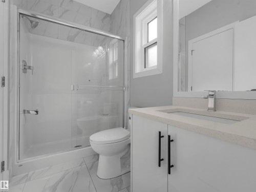 Modern bathroom featuring a walk-in shower with clear glass enclosure and chrome fixtures - 2412 14 Avenue, Edmonton, AB 