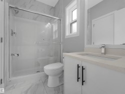 Modern bathroom featuring a walk-in shower with clear glass enclosure and chrome fixtures - 