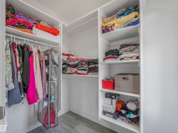 Custom closet system featuring white shelving and hanging rods - 