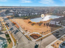 Aerial perspective highlighting a pond surrounded by residences, a paved walking path, and open green space - 