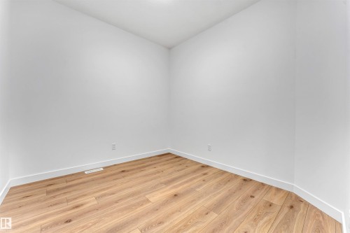 Interior space featuring wood-finish flooring, white baseboards, and neutral wall tones - 1972 210 Street, Edmonton, AB 