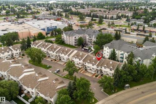 White townhome complex with brown shingled roofs and integrated garages - 3 9703 174 Street, Edmonton, AB 