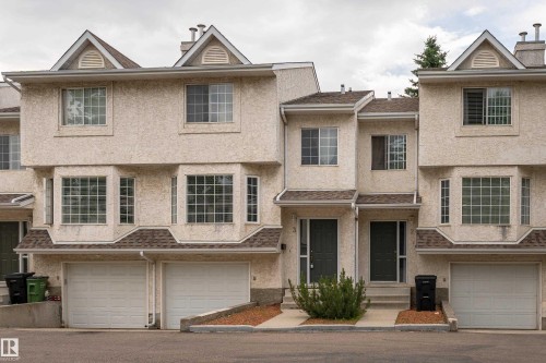 Multi-level townhome featuring stucco exterior, gabled rooflines, and individual garage access - 3 9703 174 Street, Edmonton, AB 