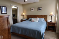 Bedroom featuring light beige walls and a wood-finish bed frame - 