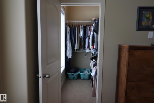 Walk-in closet featuring wire shelving, integrated hanging rods, and a window - 7492 May Common, Edmonton, AB 