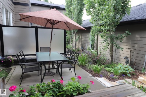 Private concrete patio with surrounding landscaping and privacy screening - 7492 May Common, Edmonton, AB 