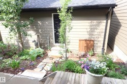 Garden pathway leading to a side entrance, featuring flagstone steps and wood decking - 
