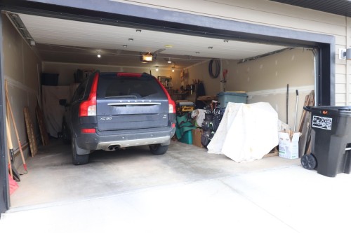 Attached two-car garage with a concrete floor, finished walls, and ceiling-mounted lighting fixtures - 7492 May Common, Edmonton, AB 