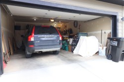 Attached two-car garage with a concrete floor, finished walls, and ceiling-mounted lighting fixtures - 
