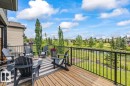 Expansive outdoor deck featuring wood flooring and black metal railings - 7613 Schmid Crescent, Edmonton, AB 
