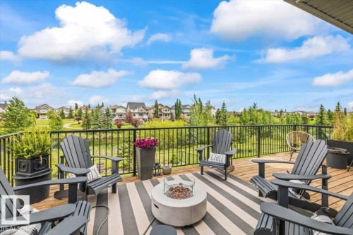 Expansive outdoor deck featuring wood flooring and a black metal railing - 7613 Schmid Crescent, Edmonton, AB 