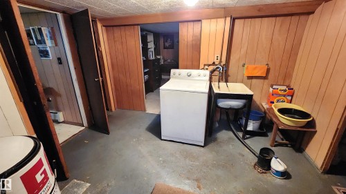 Utility area featuring wood paneling, concrete flooring, and a utility sink - 9522 110 Avenue Nw, Edmonton, AB - Indoor Photo Showing Laundry Room