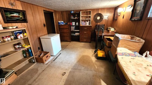 Wood paneling throughout this room, featuring a built-in shelf unit and recessed lighting - 9522 110 Avenue Nw, Edmonton, AB - Indoor