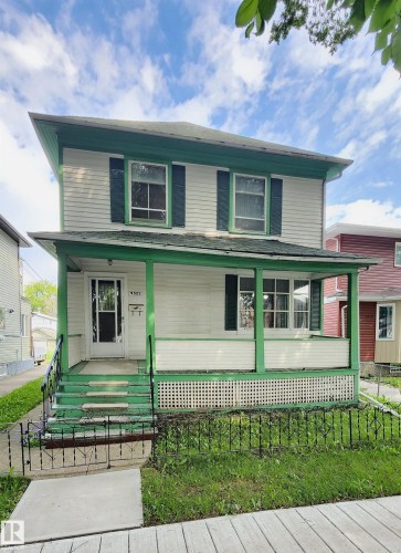 Two-story residence featuring white siding and green trim accents - 9522 110 Avenue Nw, Edmonton, AB - Outdoor With Deck Patio Veranda