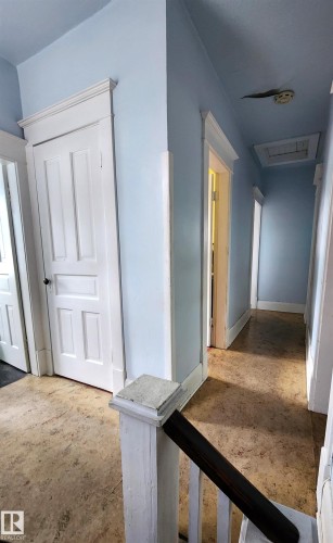Hallway featuring light blue walls, white trim, and panel doors - 9522 110 Avenue Nw, Edmonton, AB - Indoor Photo Showing Other Room