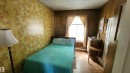 Room featuring wood-finish paneling, a single window, and floral-patterned wall covering - 9522 110 Avenue Nw, Edmonton, AB  - Indoor 