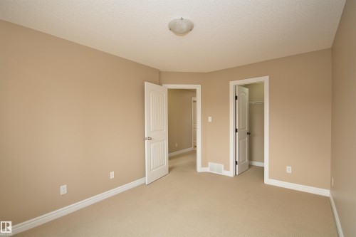 Neutral-toned carpeting and walls with white trim throughout - 11513 17 Avenue, Edmonton, AB 