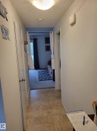 Hallway featuring light-colored vinyl tile flooring - 