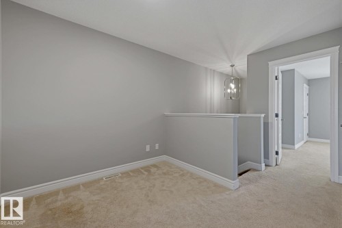 Upper-level landing featuring neutral carpeting and light gray walls - 1364 Keswick Drive Sw, Edmonton, AB 