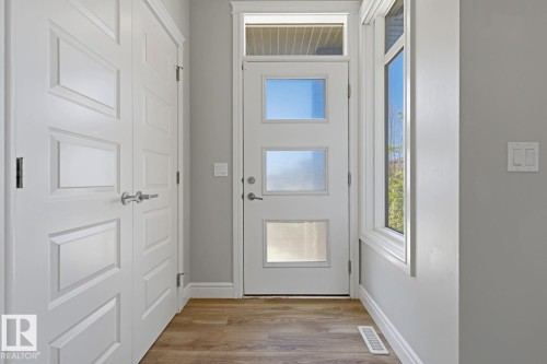 Entryway featuring a white paneled door with three clear glass inserts and a transom window - 1364 Keswick Drive Sw, Edmonton, AB 