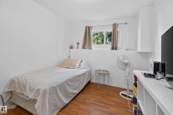 Bright room featuring wood-finish flooring and a white window frame - 
