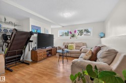 Spacious room featuring wood-finish flooring, light-colored walls, and a textured ceiling - 