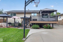 Rear exterior featuring a large elevated deck with dark railing, a ground-level deck with a covered gazebo, and a concrete patio - 