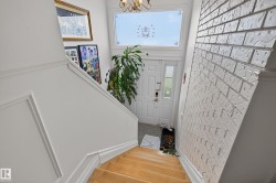 Hardwood staircase with wainscoting detail leading to a tile entry - 