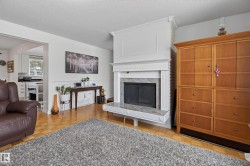 Fireplace with a stone surround and hearth, featuring an ornate white mantel and crown molding - 