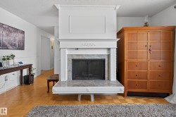 Fireplace with a decorative white mantel, fluted columns, and a tile surround - 