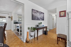Interior featuring wood-finish parquet flooring, wainscoting, and white trim - 